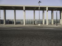 parking lot with a concrete structure with light poles, benches and traffic lights on the ground