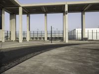 the empty parking lot is filled with vehicles and concrete pillars with shadows of columns on the floor