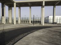 the empty parking lot is filled with vehicles and concrete pillars with shadows of columns on the floor