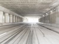 the view from inside the road through the tunnel, with snow all over the pavement