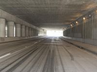 the view from inside the road through the tunnel, with snow all over the pavement