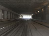 the view from inside the road through the tunnel, with snow all over the pavement