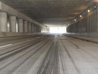 the view from inside the road through the tunnel, with snow all over the pavement