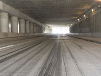 the view from inside the road through the tunnel, with snow all over the pavement