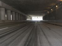 the view from inside the road through the tunnel, with snow all over the pavement