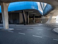 a building in an empty space with some concrete pillars over it and on the ground