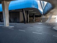 a building in an empty space with some concrete pillars over it and on the ground