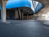 a building in an empty space with some concrete pillars over it and on the ground