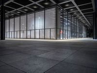 empty building with large windows that have lights coming from them and in between the floor