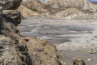 the landscape is barren, and blue sky has clouds in it and rocks on each side