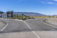 a curve road with two road markers indicating right and left turns in the middle of the desert