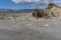 mountains with desert with rocks and dirt all around in a plain of land under clouds