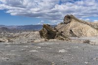 mountains with desert with rocks and dirt all around in a plain of land under clouds