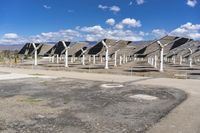 a row of solar panels on the ground of a solar park in the desert setting