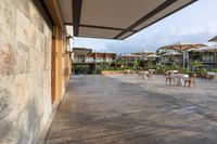 this is a patio with many tables and umbrellas outside on a wooden decking walkway