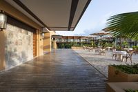 this is a patio with many tables and umbrellas outside on a wooden decking walkway