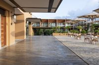 this is a patio with many tables and umbrellas outside on a wooden decking walkway