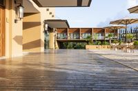 this is a patio with many tables and umbrellas outside on a wooden decking walkway