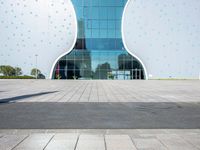 a white elephant sculpture sits in front of a large building with a large yellow bear