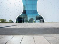 a white elephant sculpture sits in front of a large building with a large yellow bear