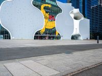 a white elephant sculpture sits in front of a large building with a large yellow bear