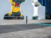 a woman on a phone sitting in front of a large white sculpture in the city