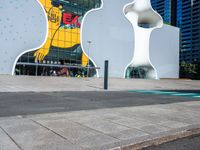 a woman on a phone sitting in front of a large white sculpture in the city