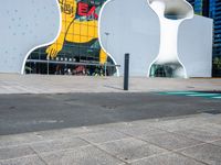 a woman on a phone sitting in front of a large white sculpture in the city