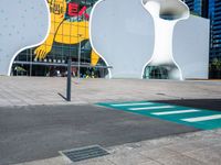 a woman on a phone sitting in front of a large white sculpture in the city