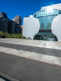 the white building has a glass front and a curved side on it's side