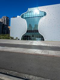 the white building has a glass front and a curved side on it's side