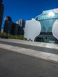 the white building has a glass front and a curved side on it's side