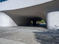 a skateboarder is attempting to do a trick on the sidewalk in front of a large white building