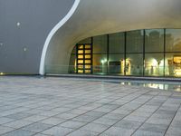 a person is standing by an open air fountain looking at the outside of a building