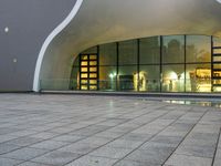 a person is standing by an open air fountain looking at the outside of a building