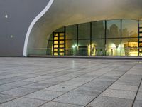 a person is standing by an open air fountain looking at the outside of a building