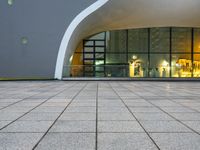 a gray building with black glass windows sitting inside of it's dome ceiling and area to the outside