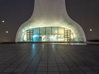 there is a small circular building that has several windows and lights in it on a night