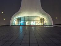 there is a small circular building that has several windows and lights in it on a night