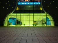 a photo of an outside of a building at night with some lights coming from it