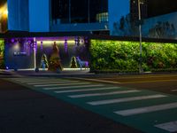 the street has many lights, trees, and other decorations on it at night time