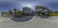 a fish eye view of a town street with people and cars driving by in the front