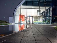 a walkway with concrete slabs outside and reflections on the water in the background as seen from a high angle