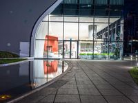 a walkway with concrete slabs outside and reflections on the water in the background as seen from a high angle