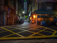 a dark city street with a bicycle parking space on the sidewalk in front of a shop front