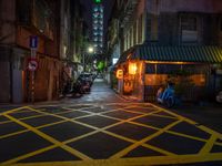 a dark city street with a bicycle parking space on the sidewalk in front of a shop front