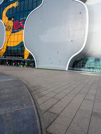 this is a white apple shaped building in a big city with people walking outside it