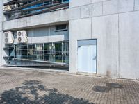 this is an image of an apartment building with concrete facade and side parking space in front