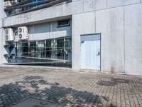 this is an image of an apartment building with concrete facade and side parking space in front