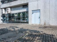 this is an image of an apartment building with concrete facade and side parking space in front